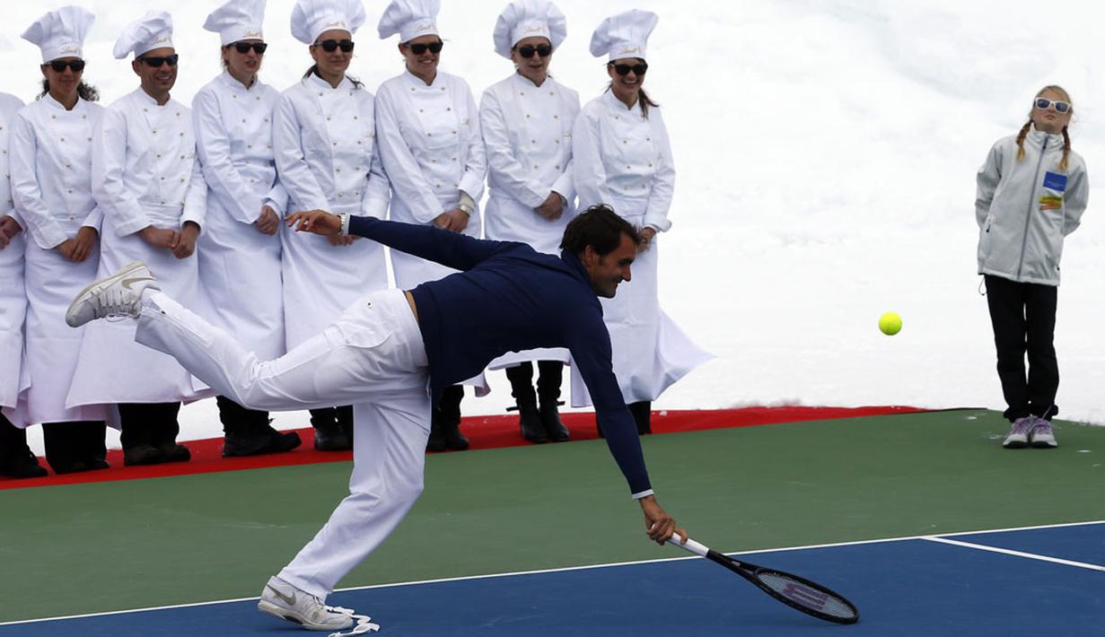 Roger Federer berusaha mengembalikan bola ke pemain ski AS, Lindsey Vonn, saat berlaga di sesi promosi gletser Aletsch, Jungfraujoch, (17/7/2014). (REUTERS/Denis Balibouse)