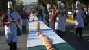 Suasana pembuatan kue raja sepanjang 2.063,43 meter di Saltillo, Negara Bagian Coahuila, Meksiko, 6 Januari 2019. Kue raja tersebut memecahkan Guinness World Record sebagai kue terpanjang di dunia. (Julio Cesar AGUILAR/AFP)
