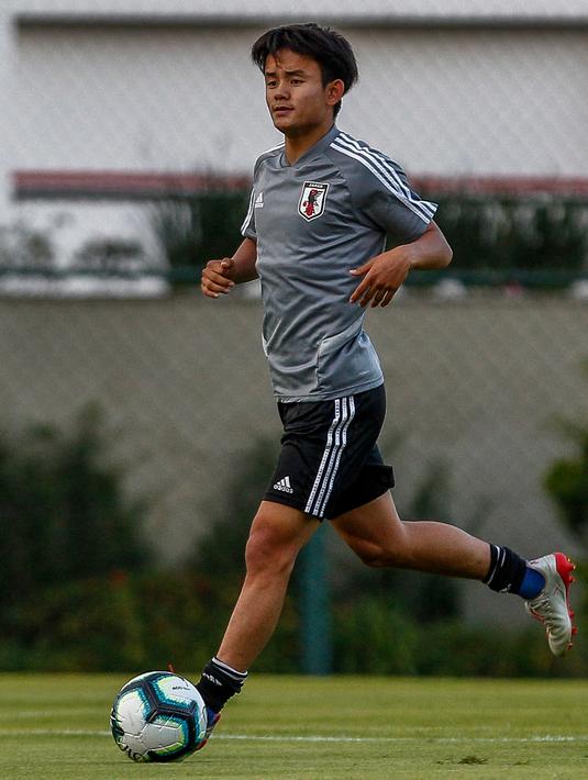Gelandang Jepang, Takefusa Kubo menggiring bola saat sesi latihan jelang turnamen Copa America 2019 di Sao Paulo, Brasil (13/6/2019). Pemain berusia 18 tahun akan masuk ke dalam skuad tim B Madrid, Castilla, untuk musim depan. (AFP Photo/Miguel Schincariol)