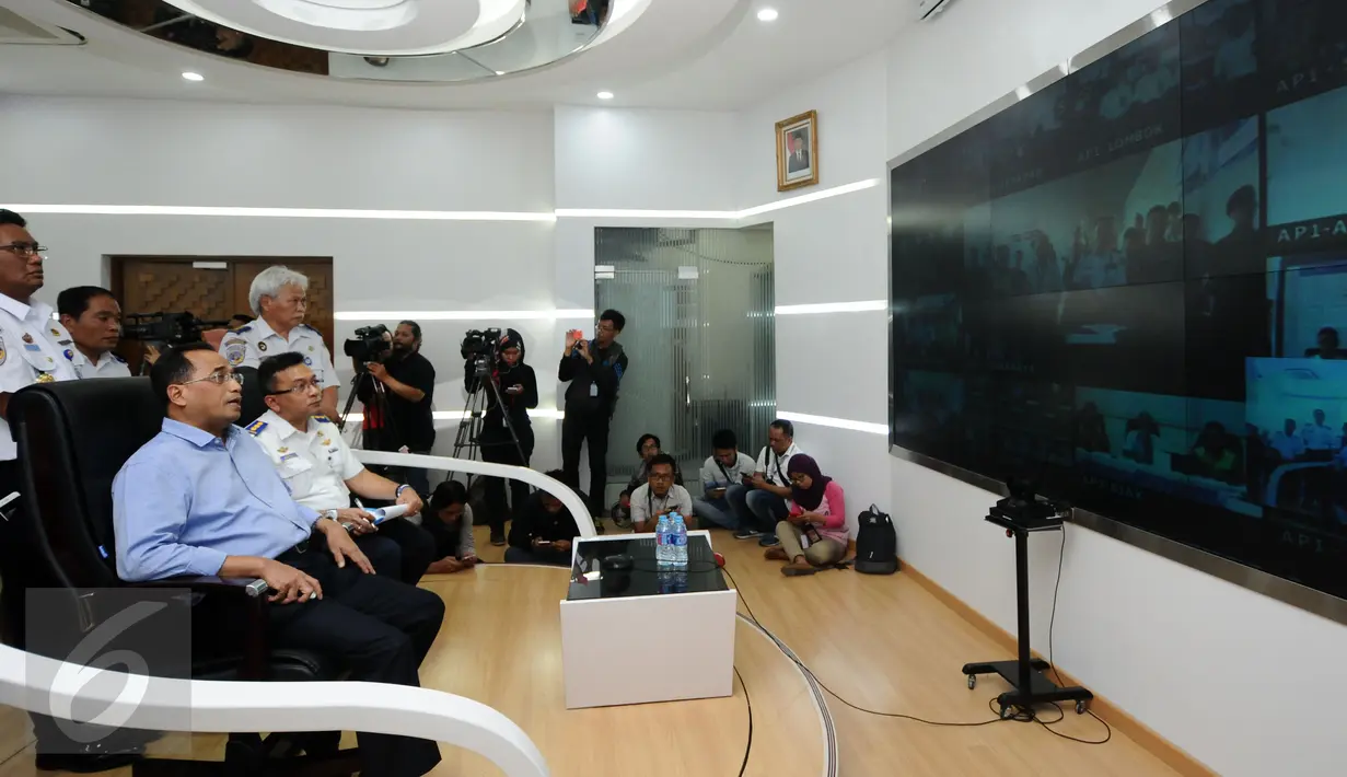 Menhub, Budi Karya Sumadi (kedua kiri) memberi arahan saat melakukan teleconference di Kemenhub, Jakarta, Minggu (25/12). Menhub Budi Karya memastikan angkutan pada Natal 2016 dan Tahun Baru 2017 berjalan lancar. (Liputan6.com/Helmi Fithriansyah)