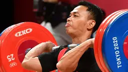 Eko Yuli Irawan berlomba di cabang olahraga angkat besi 61kg putra Olimpiade Tokyo 2020 di Tokyo International Forum, Tokyo, Minggu (25/7/2021). (Foto: AFP/Vincenzo Pinto)