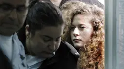 Ahed Tamimi dikawal petugas keamaan Isreal saat tiba di pengadilan militer Israel di penjara Ofer, Israel (13/2). Ahed Tamimi dikenai dakwaan atas 12 pelanggaran, termasuk menyerang pasukan keamanan dan menghasut kekerasan. (AFP/Thomas Coex)