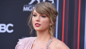Penyanyi Taylor Swift berpose saat tiba menghadiri Billboard Music Awards di MGM Grand Garden Arena di Las Vegas (20/5).Taylor Swift tampil cantik dengan gaun Versace warna merah muda dengan belahan paha tinggi. (AP Photo/Jordan Strauss)