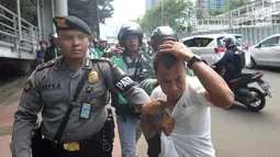 Terduga copet menutupi kepalanya dengan tangan saat akan diamankan menuju Mapolda Metro Jaya di Jalan Jenderal Sudirman, Jakarta (2/4). Polisi mengamankan tiga terduga copet. (Merdeka.com/Arie Basuki)