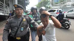 Terduga copet menutupi kepalanya dengan tangan saat akan diamankan menuju Mapolda Metro Jaya di Jalan Jenderal Sudirman, Jakarta (2/4). Polisi mengamankan tiga terduga copet. (Merdeka.com/Arie Basuki)