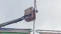 Tangkapan layar video dua pekerja jatuh dari mobil crane saat memperbaiki lampu jalan di Flyover Kalibalok, Bandar Lampung.  Foto (Istimewa).