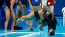 Anggota tim polo air putri AS mendorong pelatihnya, Adam Krikorian, ke kolam setelah meraih emas dengan mengalahkan Belanda di Kejuaraan Dunia Akuatik 2015 di Kazan, Rusia. (7/8/2015). (Reuters/Michael Dalder)