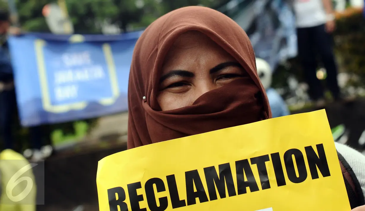 Aktivis Koalisi Selamatkan Teluk Jakarta membentangkan tulisan saat aksi di depan Kedubes Belanda di Jakarta, Rabu (23/11). Mereka meminta upaya investasi pembangunan infrastruktur di Teluk Jakarta dihentikan. (Liputan6.com/Helmi Fithriansyah)