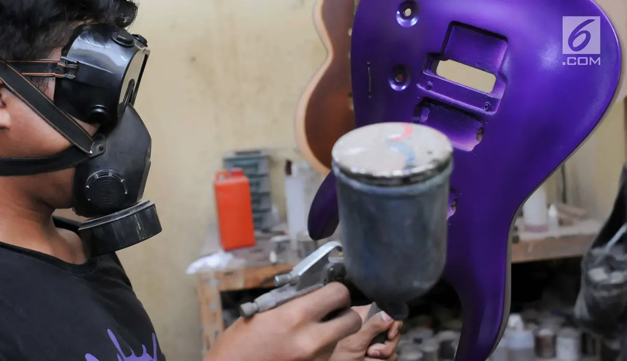 Pengrajin mengecat untuk menyelesaikan pembuatan gitar di Syukey Guitars, Cirendeu, Ciputat Timur (3/4). Selain membuat gitar baru, tempat ini juga melayani perbaikan dan modifikasi. (Merdeka.com/Arie Basuki)