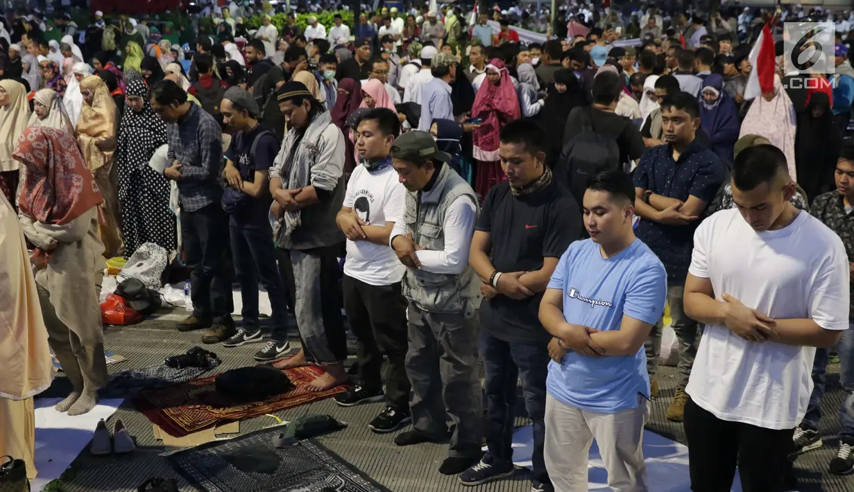 Peserta aksi massa Gerakan Nasional Kedaulatan Rakyat melakukan salat maghrib saat unjuk rasa di depan Gedung Bawaslu, Jalan MH Thamrin, Jakarta, Selasa (21/5/2019). Dalam aksinya, mereka Bawaslu memeriksa hasil Pemilu 2019 yang dinilai banyak terdapat kecurangan. (Liputan6.com/Helmi Fithriansyah)