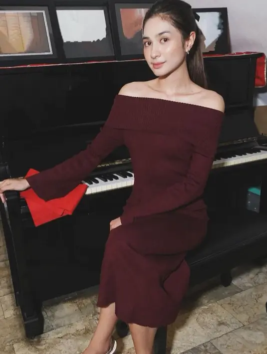 Mikha Tambayong menikah dengan Deva Mahendra awal tahun 2023. Saat Natal ia pun mengenakan dress off shoulder lengan panjang warna maroon saat sah menjadi seorang istri. [@mikhatambayong]