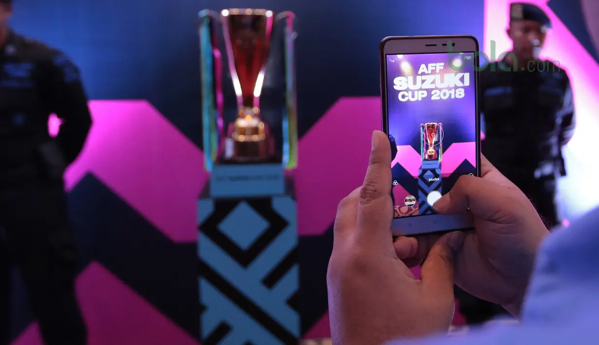 Media mengambil gambar trofi Piala AFF Suzuki Cup 2018 di Hotel Mulia, Jakarta, Rabu (2/5/2018). Indonesia berada satu grup dengan Thailand, Singapura dan Filipina. (Bola.com/Nick Hanoatubun)