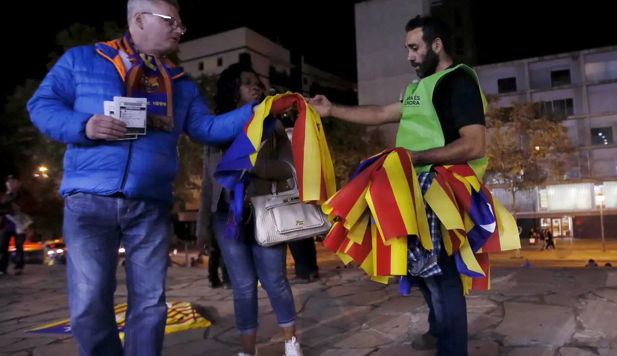 Seorang sukarelawan membagikan bendera "Estelada" (bendera separatis Catalan) sebelum laga Liga Champions grup E antara Barcelona dan Bate Borisov di Stadion Camp Nou, Barcelona, Spain, Rabu (4/11/2015). (REUTERS/Albert Gea)