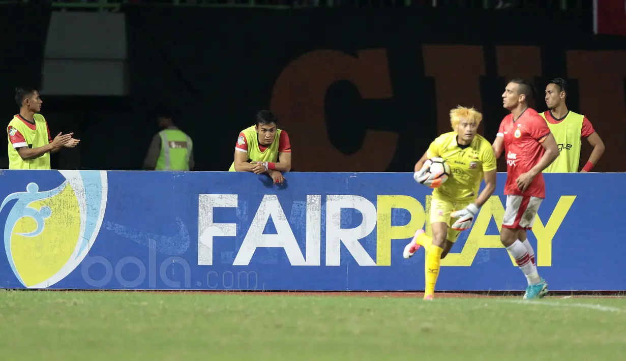 Bek Persija Jakarta, Gunawan bersandar pada papan iklan menyaksikan timnya melawan Madura United pada lanjutan Liga 1 2017 di Stadion Patriot, Bekasi, Kamis (4/5/2017). Persija kalah dari Madura 0-1. (Bola.com/Nicklas Hanoatubun)