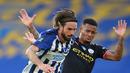 Gelandang Brighton and Hove Albion, Davy Propper (kiri) berebut bola dengan striker Manchester City, Gabriel Jesus pada Pekan ke-35 Liga Inggris di stadion The American Express, Minggu (12/7/2020). Manchester City berpesta gol di markas Brighton. (Julian Finney / POOL / AFP)