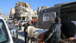 Seorang pria mengevakuasi korban setelah kota tersebut diserang pasukan pro Presiden Bashar al-Assad di Aleppo Timur, Suirah (15/12). Ribuan warga telah dievakuasi di kota yang kini porak-poranda. (REUTERS/Abdalrhman Ismail)
