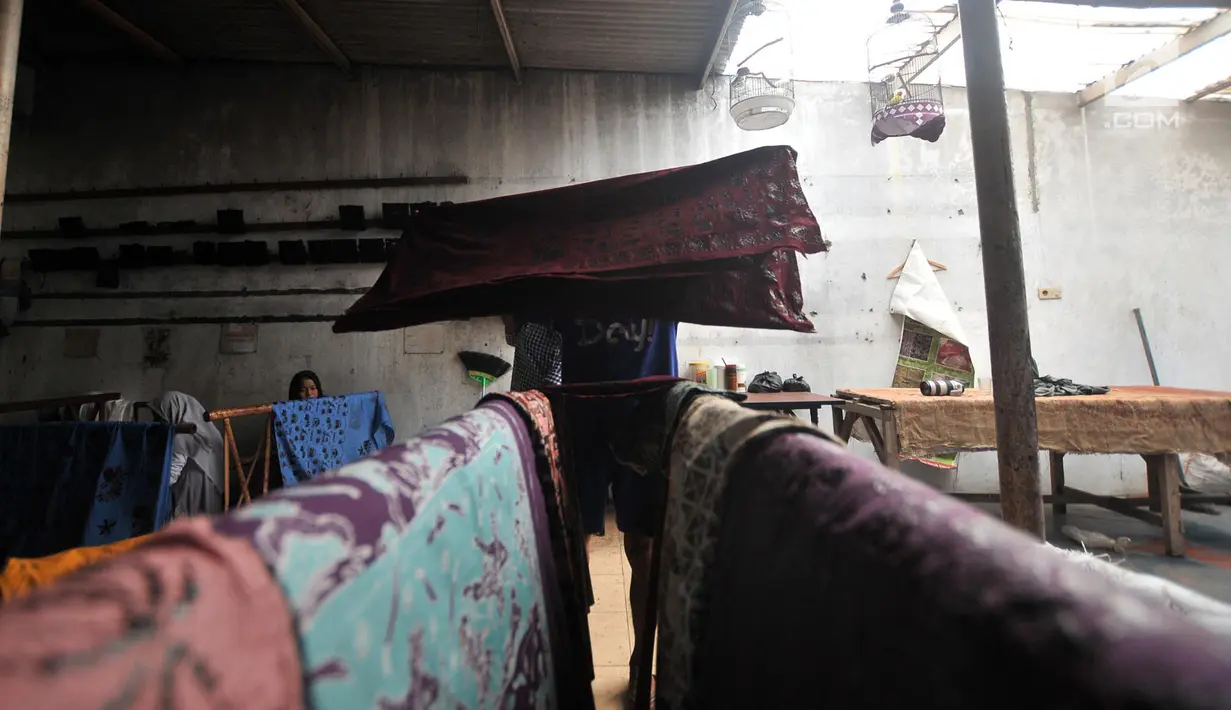 Pengrajin mengeringkan kain batik Betawi usai dicuci di rumah produksi Batik Seraci, Kampung Kebon Kelapa, Bekasi, Jawa Barat, Selasa (2/10). Dalam satu bulan rumah produksi Batik Seraci mampu meraih omzet sekitar Rp 30 juta. (Merdeka.com/Iqbal Nugroho)
