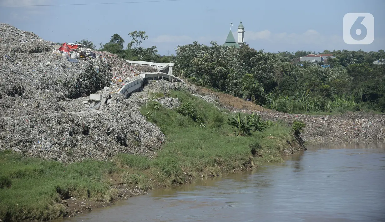 Pemandangan sampah yang longsor di TPA Cipeucang, Serpong, Tangerang Selatan, Banten, Sebtu (23/5/2020). Turap penahan sampah TPA Cipeucang longsor pada 22 Mei 2020 dan hampir menutupi aliran Sungai Cisadane yang berada di sebelahnya. (merdeka.com/Dwi Narwoko