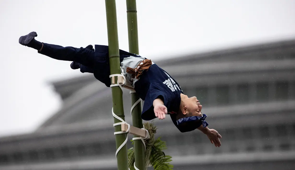 Seorang anggota Asosiasi Pelestarian Pemadam Kebakaran Edo melakukan teknik pemadam kebakaran tradisional Jepang saat latihan pemadam kebakaran Tahun Baru di Tokyo, Jepang, 6 Januari 2022. (Behrouz MEHRI/AFP)