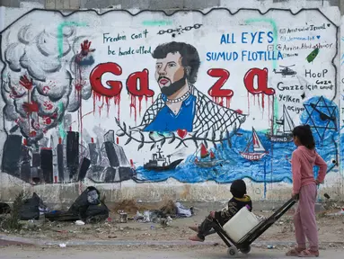 Anak-anak Palestina melihat mural yang menggambarkan pencegatan kapal-kapal yang berpartisipasi dalam Armada Sumud Global, sebuah misi bantuan kemanusiaan yang dipimpin sipil ke Gaza melalui laut, di Nuseirat, Jalur Gaza Tengah pada 19 Mei 2026. (Eyad Baba/AFP)