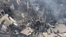 Orang-orang mencari korban di atas reruntuhan bangunan yang hancur usai pengeboman Israel, di Khan Younis di Jalur Gaza Selatan pada 26 Oktober 2023. (Mahmud HAMS/AFP)