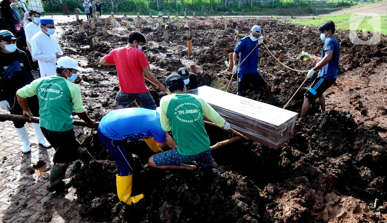 Petugas memakamkan korban COVID-19 warga Tangerang Selatan yang meninggal di Bandung di TPU Jombang, Tangerang Selatan, Banten, Senin (21/6/2021). Korban COVID-19 yang dimakamkan dalam satu hari rata-rata 5 sampai 10 jenazah. (merdeka.com/Arie Basuki)
