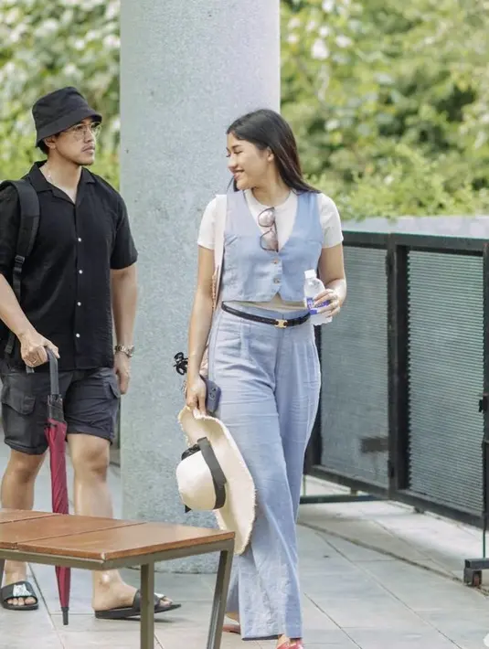 Erina memilih mengenakan two pieces warna baby blue, terdiri dari atasan vest dan celana panjang bahannya. Ia pun memadukannya dengan atasan tshirt putih sebagai inner.  Credit: Instagram (@erinagudono)
