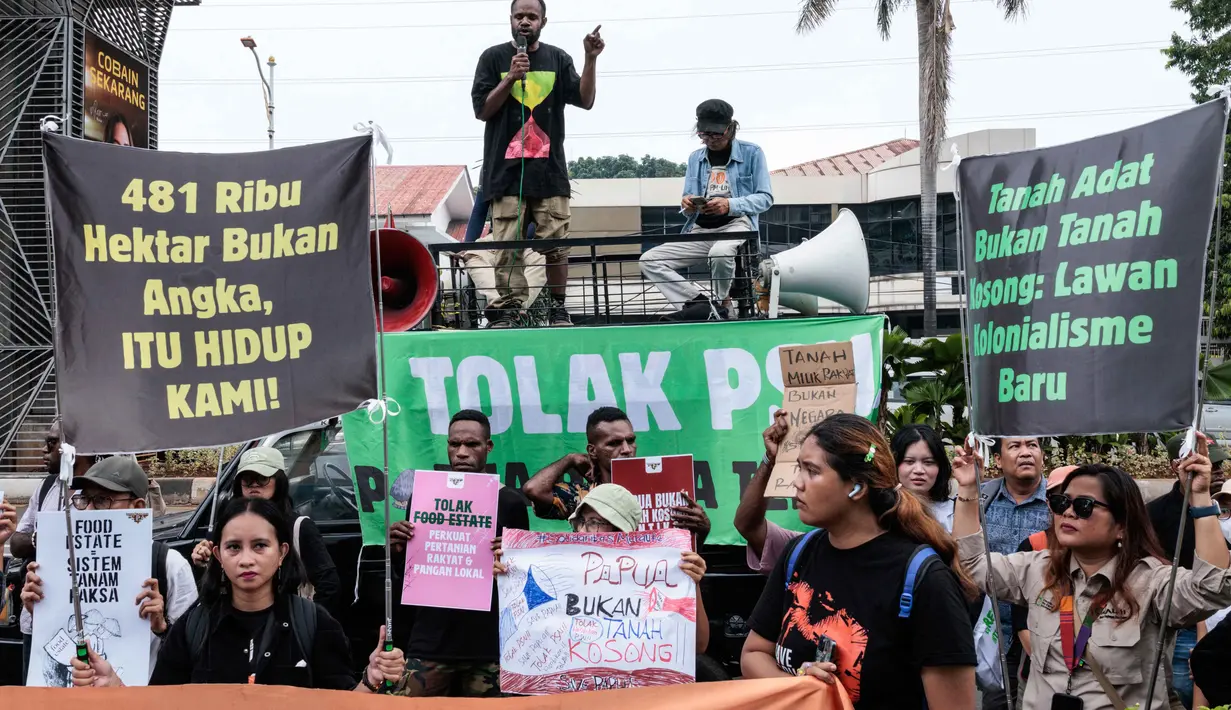 Para pengunjuk rasa menggelar aksi menentang rencana pemerintah untuk melepaskan kawasan hutan di Papua Selatan bagi proyek-proyek strategis nasional di bidang pangan, energi, dan pertahanan di depan Kantor Menteri Agraria dan Tata Ruang/Kepala Badan Pertanahan Nasional (ATR/BPN), Selasa (7/10/2025). (Yasuyoshi CHIBA/AFP)