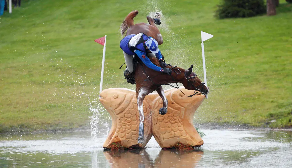 Atlet berkuda Rusia, Mikhail Nastenko, terjatuh saat melewati rintangan di nomor cross country Kejuaraan Eropa FEI di Blair Castle, Skotlandia. Sabtu (12/9/2015). (Reuters/Russell Cheyne)
