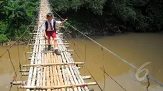 Seorang siswa SD melintas di atas jembatan gantung di atas kali Ciliwung untuk menuju ke sekolah, Jakarta, Selasa (17/3/2015). Jembatan tersebut menghubungkan Kelapa Dua Depok dengan Lenteng Agung (Liputan6.com/Yoppy Renato)
