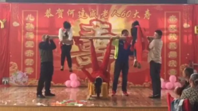 Seorang wanita di Cina menunjukkan kekuatan kakinya dengan mengangkat beberapa orang secara bersamaan