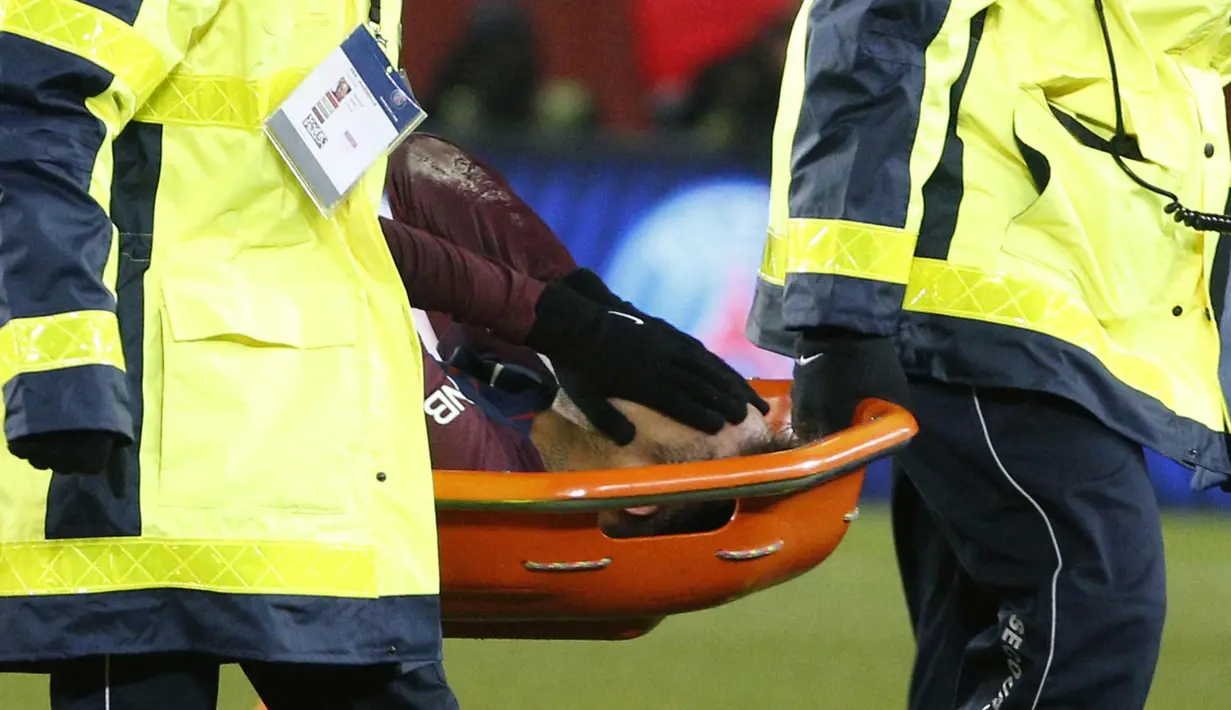 Neymar menutup wajahnya saat ditandu keluar lapangan oleh tim medis pada pertandingan melawan Marseille di Liga Prancis di Stadion Parc des Princes, (25/2). PSG menang 3-0 di pertandingan tersebut. (AFP Photo/Geoffroy Van Der Hasselt)