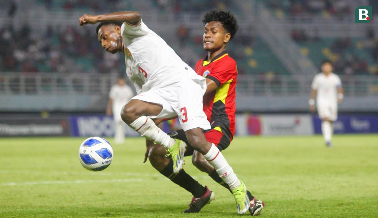 <p>Pemain Timnas Indonesia U-19, Alexandro Felix Kamuru (kiri) berusaha melewati adangan pemain Timnas Timor Leste U-19, Rui Juman Abel pada laga matchday ketiga Grup A Piala AFF U-19 di Stadion Gelora Bung Tomo, Surabaya. Selasa (23/7/2024). (Bola.com/Aditya Wany)</p>