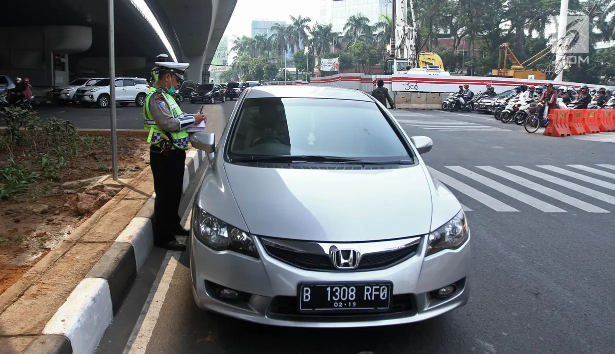 Polisi memberikan surat tilang kepada pengemudi mobil berpelat nomor genap di Jalan MT Haryono, Jakarta, Rabu (1/8). Polisi hari ini mulai memberlakukan sanksi tilang kepada pelanggar aturan di kawasan perluasan ganjil genap (Merdeka.com/Iqbal S. Nugroho)