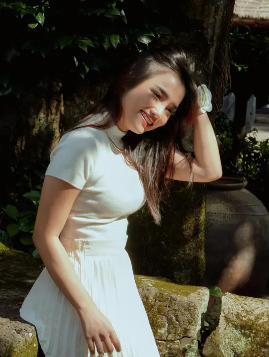 Ia memadukan short sleeve turtleneck putih dengan pleated long skirt berwarna senada [@fuji_an]