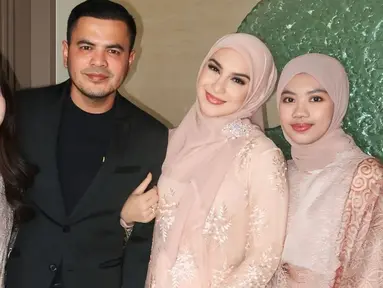 Irish Bella untuk pertama kalinya membagikan momen kondangan bersama keluarga barunya. Dengan senyum semringah, Irish tampak menggandeng suaminya yang berpenampilan rapi mengenakan setelan jas hitam. Sementara, penampilannya tampak senada dengan dua anak sambungnya. (Liputan6.com/IG/@_irishbella_)