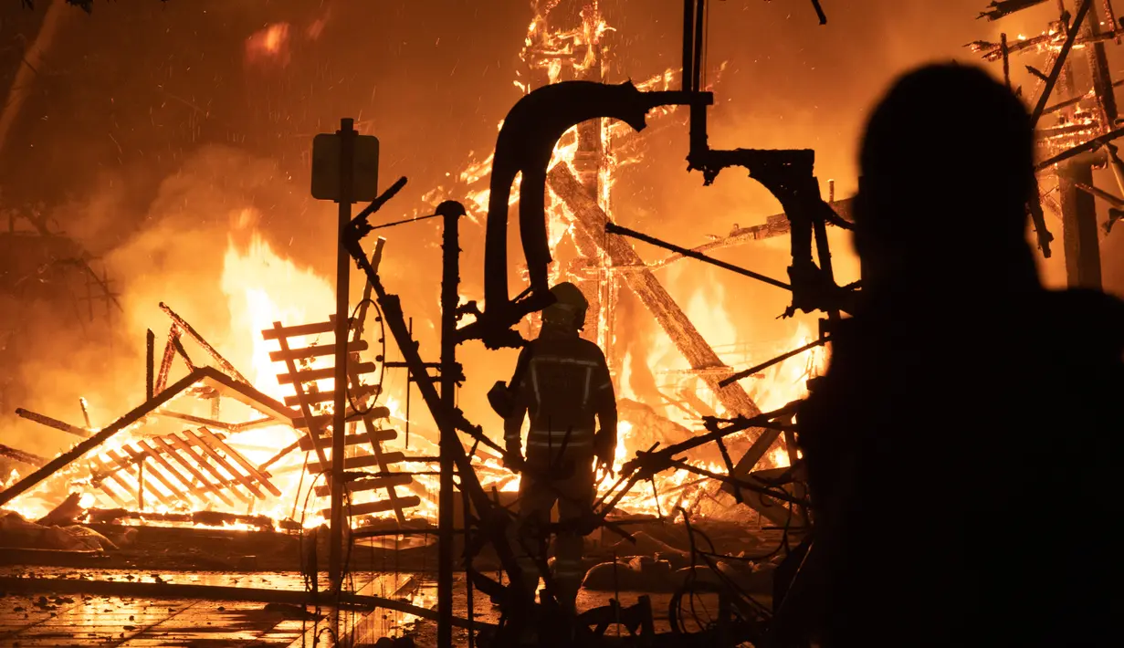 Pemadam kebakaran mengendalikan api pada malam terakhir festival tradisional Fallas di Valencia, Spanyol, Selasa (19/3). Selama Fallas biasanya dipamerkan beragam monumen satir bertema sesuatu yang tengah kontroversial di masyarakat. (JOSE JORDAN / AFP)