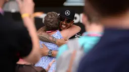 Pebalap Tim Mercedes AMG Petronas F1, Lewis Hamilton, memeluk ibunya setelah memenangi F1 GP Inggris di Sirkuit Silverstone, Inggris. (5/7/2015). (AFP PHOTO/OLI SCARFF)