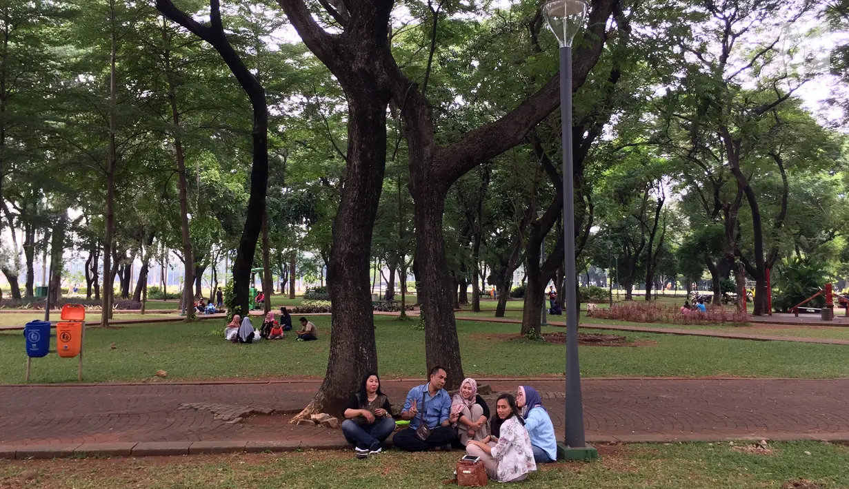 Pengunjung bercengkerama di sekitar Taman Monas, Jakarta, Rabu (17/1). Gubernur Anies Baswedan melalui Kepala Unit Pengelola Kawasan (UPK) Monas mencabut larangan menginjak rumput di kawasan tersebut. (Liputan6.com/Immanuel Antonius)