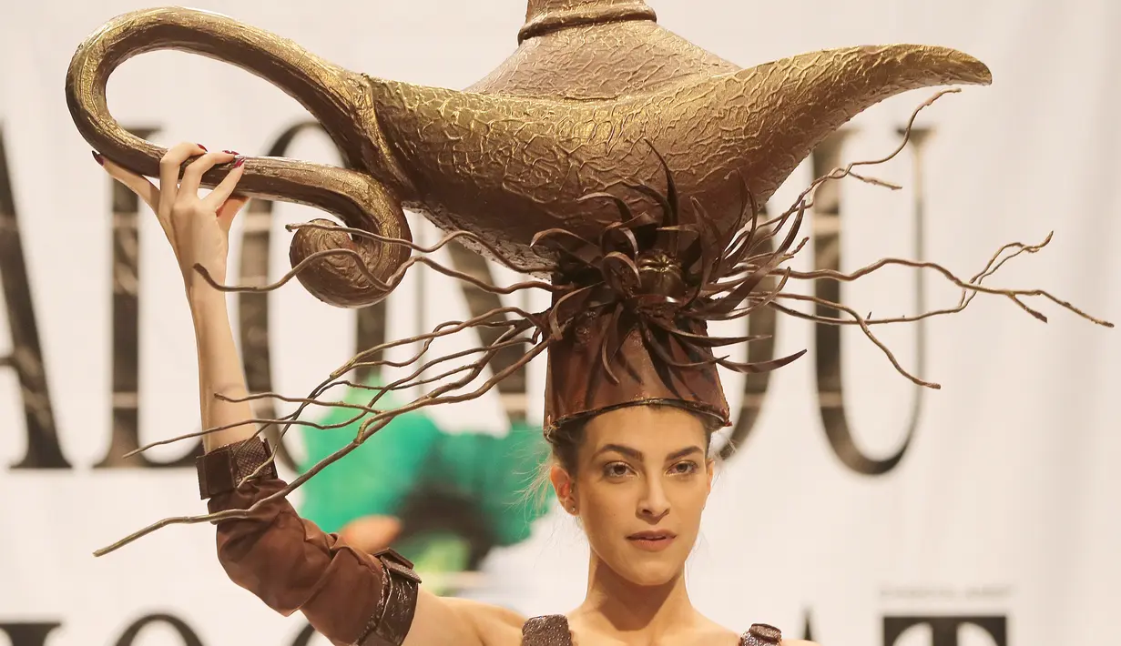 Model berjalan diatas catwalk mengenakan busana yang terbuat dari cokelat lengkap dengan atribut kepala saat Beirut Cooking Festival ke-7 di Lebanon (16/11). Model juga membawakan kreasi cokelat dalam bentuk lainnya. (AFP Photo/Joseph Eid)