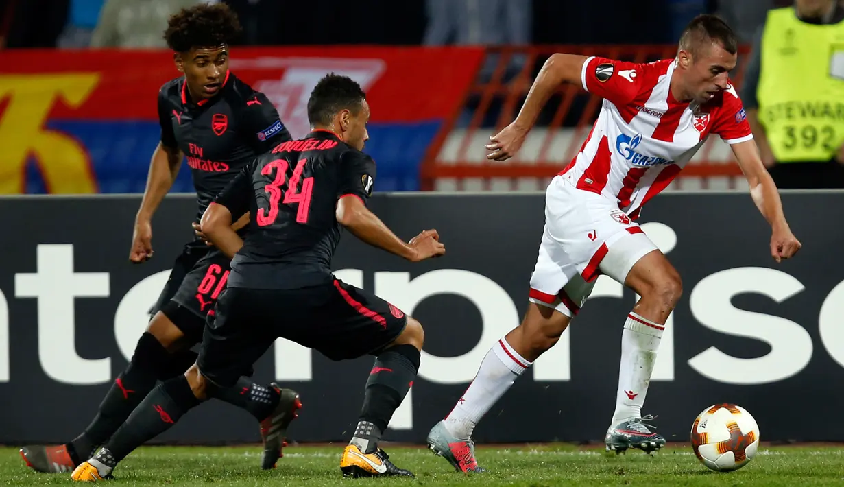 Pemain Red Star Belgrade, Nenad Krsticic berusaha menghindari kawalan pemain Arsenal Francis Coquelin dan Reiss Nelson pada pertandingan Grup H Liga Europa di Stadion Rajko Mitic, Kamis (19/10). The Gunners menang tipis 1-0. (AP/Darko Vojinovic)