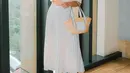 Tampil dengan outfit serba putih, gaya simpel namun cantik ala Jessica Mila ini bisa jadi inspirasi. Atasan beraksen pleats serasi dengan rok panjang, dan tas yang ditentengnya. Foto: Instagram.