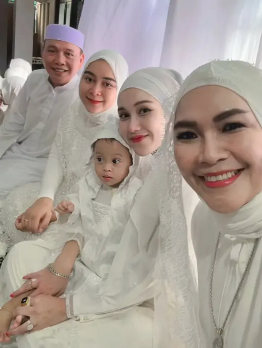 Keluarga Ayu pun tampil kompak dengan mengenakan busana muslim warna putih. Tampak Ayu pun menggendong keponakannya. [@ayutingting92]