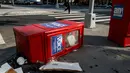 Sebuah kotak surat kabar Village Voice tergeletak di samping tempat sampah di Manhattan, AS (22/8). Village Voice  adalah surat kabar mingguan tertua dan paling terkenal di AS. (Drew Angerer/Getty Images/AFP)