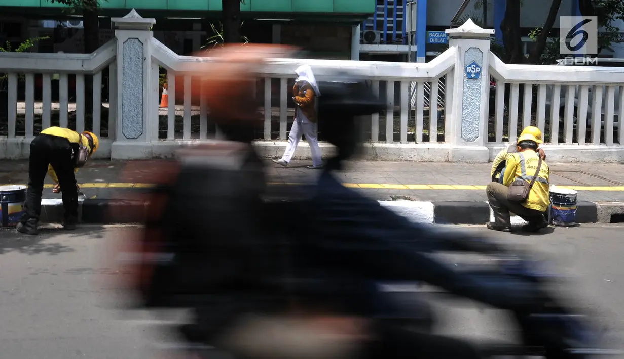 Petugas Suku Dinas Bina Marga Jakarta Timur saat menyelesaikan pengecatan trotoar di Jalan Persahabatan Raya, Jakarta, Rabu (27/3). Kegiatan pengecatan ini rutin dilakukan guna merawat sekaligus mempercantik jalur pedestrian tersebut. (merdeka.com/Iqbal S. Nugroho)