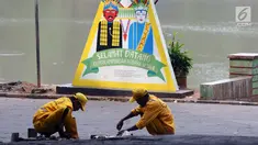 Petugas melakukan perbaikan jalan masuk Setu Babakan, Jakarta, Jumat (14/7). Setu Babakan akan menjadi lokasi pelaksanaan Lebaran Betawi 2017 yang akan digelar pada 21 - 23 Juli 2017. (Liputan6.com/Helmi Fithriansyah)