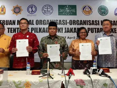 Ketua Umum PBNU Said Aqil Siradj menujukan hasil deklarasi bersama pemuka agama lain usai pembacaan seruan moral tentang Pilkada DKI Jakarta putaran kedua di Jakarta, Senin (17/4). (Liputan6.com/Johan Tallo)
