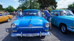 Orang-orang mengamati bagian dalam mobil antik GAZ Volga M21 dalam sebuah festival yang diadakan di Karosta di Kota Liepaja, Latvia, pada 14 Juni 2020. (Xinhua/Janis Laizans)