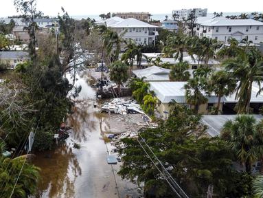 Foto udara memperlihatkan sebuah jalan yang tergenang air dan dipenuhi puing-puing setelah terjangan Badai Milton, di Siesta Key, Florida, pada tanggal 10 Oktober 2024. (CHANDAN KHANNA/AFP)