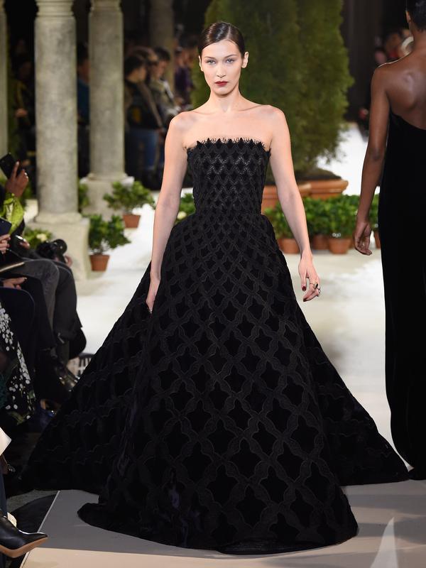 Model Bella Hadid berjalan di atas catwalk mengenakan koleksi terbaru dari Oscar de la Renta dalam New York Fashion Week, AS (12/2). Bella Hadid tampil cantik dengan gaun hitam panjang tanpa lengan. (AFP Photo/Slaven Vlasic)